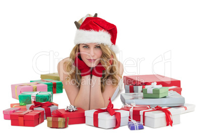 Woman in santa hat laying on the floor with gifts around her