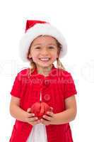 Cute little girl wearing santa hat holding bauble