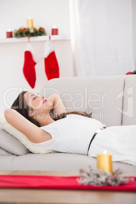 Relaxed brunette lying on the couch at christmas