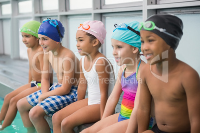 Cute swimming class smiling poolside