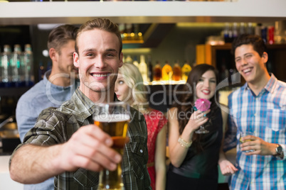 Happy young man holding pint of beer