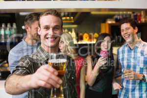 Happy young man holding pint of beer