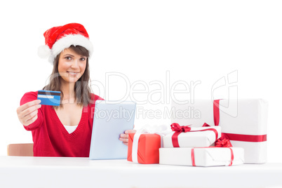 Festive brunette shopping online with tablet pc