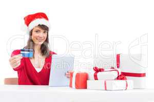 Festive brunette shopping online with tablet pc