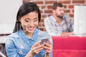 Young casual woman text messaging