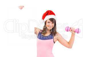 Festive fit brunette smiling at camera holding poster