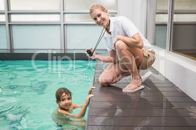 Pretty swimming coach showing boy his time