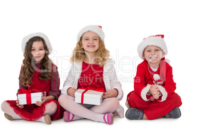 Festive little siblings smiling at camera holding gifts