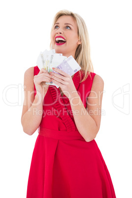 Stylish blonde in red dress holding cash