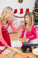 Festive mother and daughter making christmas cookies