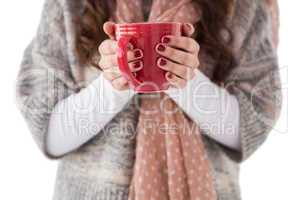 Woman in winter clothes holding a hot drink