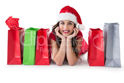 Festive brunette lying near shopping bags