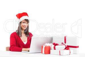 Festive brunette shopping online with laptop