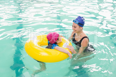 Cute little boy learning to swim with coach