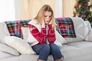 Woman with headache sitting on sofa