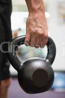 Cropped man holding kettle bell