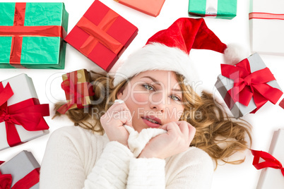 Woman in warm clothing laying on the floor with gifts