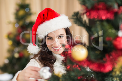 Beauty brunette decorating a christmas tree