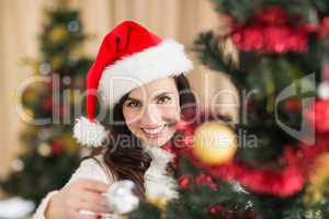 Beauty brunette decorating a christmas tree