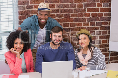 Creative team using laptop in meeting