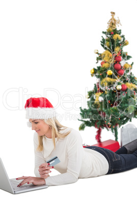 Festive blonde shopping online with laptop