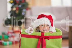 Cute little girl sitting in giant christmas gift