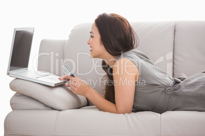 Beauty brunette using her laptop on the couch