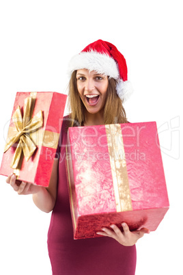 Surprised pretty brunette in santa hat opening gift