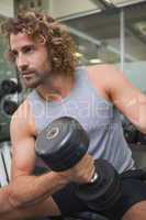 Young man exercising with dumbbell in gym