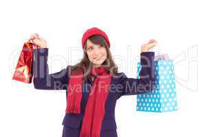 Pretty brunette holding up shopping bags