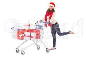 Cute woman in santa hat with shopping trolley