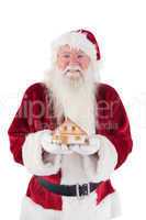 Santa holds a tiny house in his hands