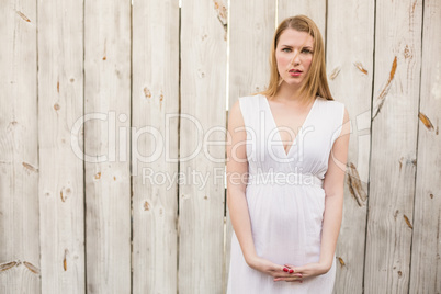 Elegant blonde woman standing while looking at camera