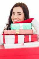 Portrait of a smiling brunette holding pile of gifts
