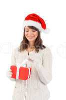 Festive brunette in santa hat opening a gift