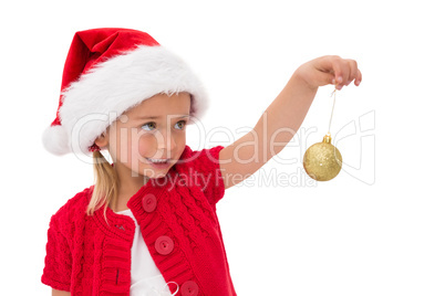 Cute little girl wearing santa hat holding bauble