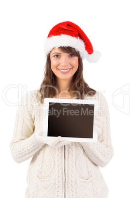 Festive brunette holding a tablet pc