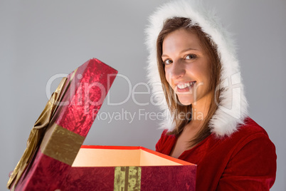 Festive pretty brunette opening a gift