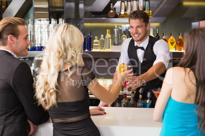 Attractive friends being served cocktails