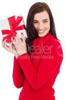 Smiling brunette in red jumper hat showing a gift