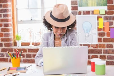 Female interior designer using laptop at desk