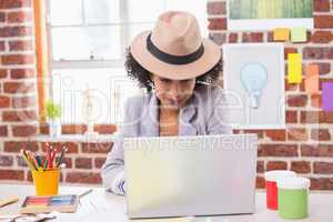 Female interior designer using laptop at desk