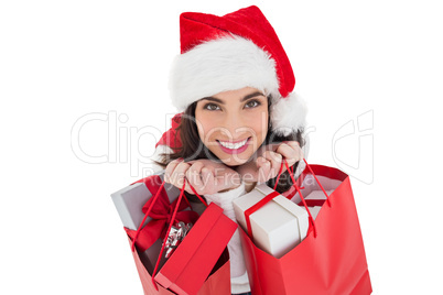 Smiling brunette holding shopping bags full of gifts