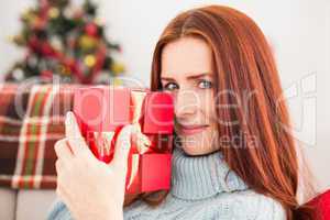 Festive redhead with gift on the couch