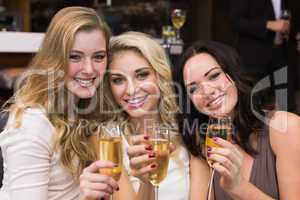 Happy friends drinking champagne together