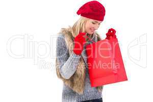 Blonde in winter clothes looking in shopping bag