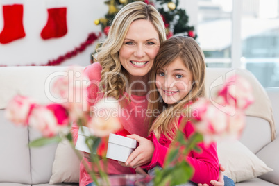 Little girl giving her mother a christmas gift