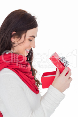 Smiling brunette opening christmas present