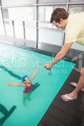 Swimming coach showing time to little girl