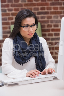 Serious casual young woman using computer